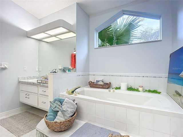 bathroom with tiled tub and vanity