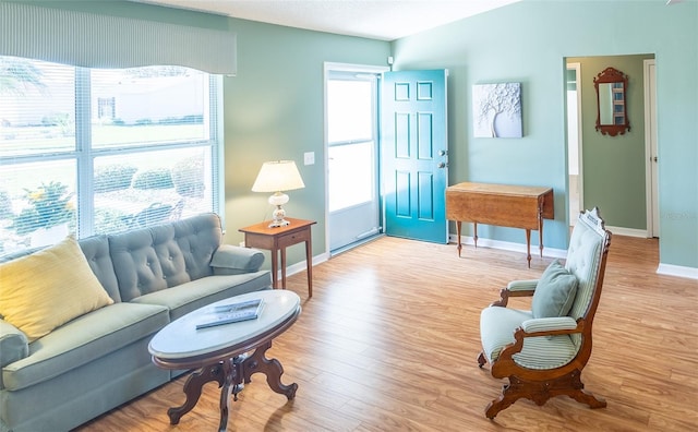 living area with baseboards and light wood finished floors