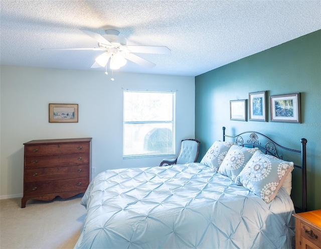 bedroom with a ceiling fan, a textured ceiling, and light colored carpet