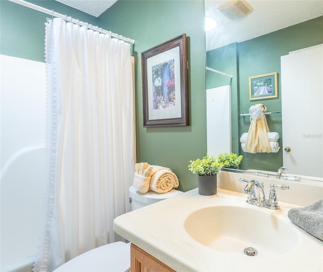 bathroom with a textured ceiling, toilet, a shower with shower curtain, visible vents, and vanity