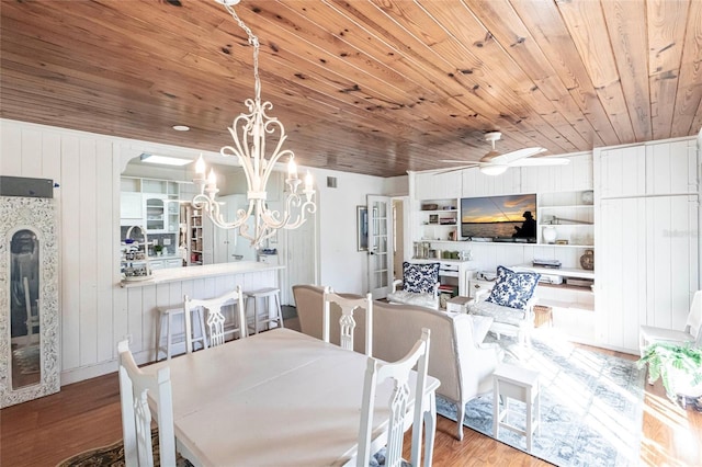 dining room with wood ceiling, ceiling fan with notable chandelier, built in shelves, and light hardwood / wood-style floors