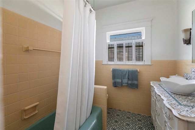 bathroom with vanity, tile patterned floors, tile walls, and shower / bath combo with shower curtain