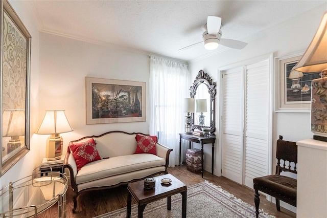 sitting room featuring hardwood / wood-style flooring, crown molding, a textured ceiling, and ceiling fan