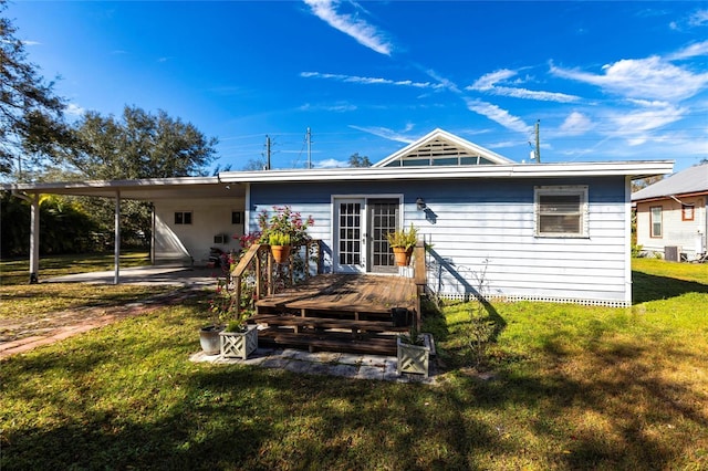 rear view of house with cooling unit, a wooden deck, and a lawn