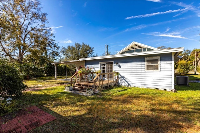 back of property featuring cooling unit, a wooden deck, and a lawn