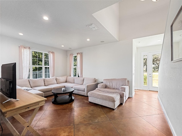 living room featuring tile patterned flooring, a textured ceiling, and a wealth of natural light