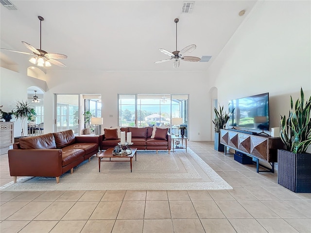 living room with ceiling fan, high vaulted ceiling, and light tile patterned floors