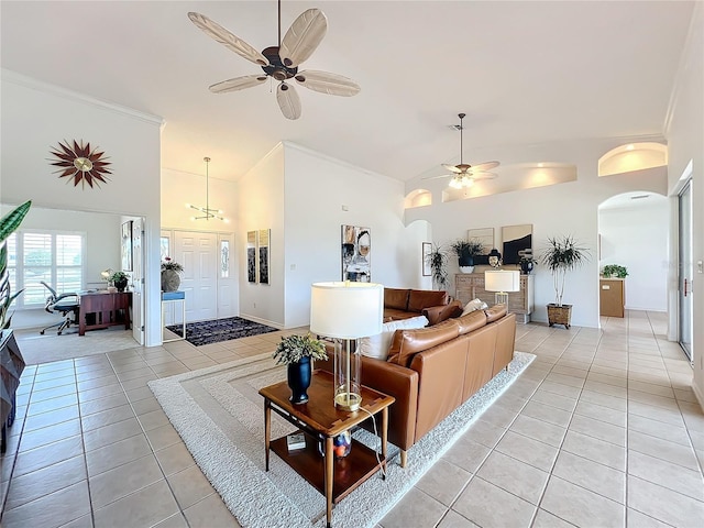 tiled living room with ceiling fan and high vaulted ceiling