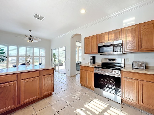 kitchen with ceiling fan, ornamental molding, appliances with stainless steel finishes, and light tile patterned floors