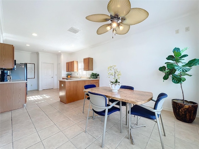 dining space featuring light tile patterned flooring, ceiling fan, and crown molding