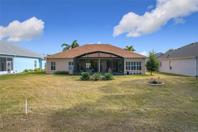 back of property with glass enclosure and a lawn