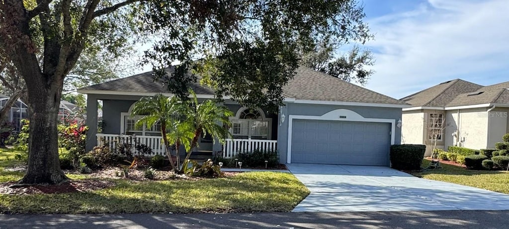 ranch-style house with a garage, covered porch, and a front lawn