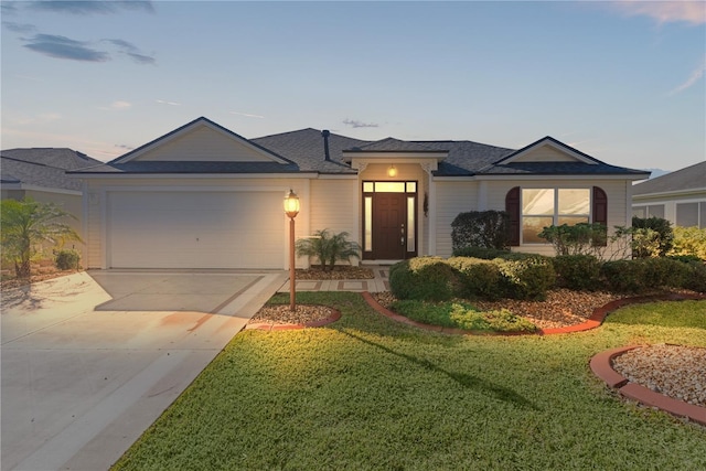 view of front of property with a garage and a lawn