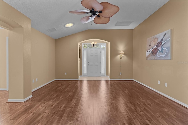 foyer with hardwood / wood-style flooring, lofted ceiling, and ceiling fan with notable chandelier