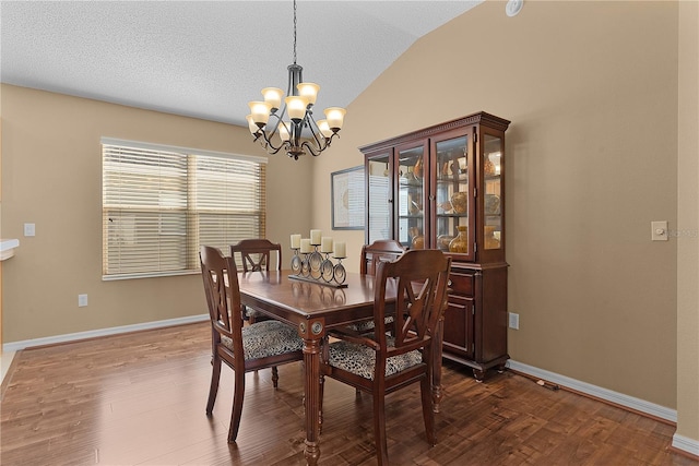 dining space featuring an inviting chandelier, hardwood / wood-style flooring, lofted ceiling, and a textured ceiling