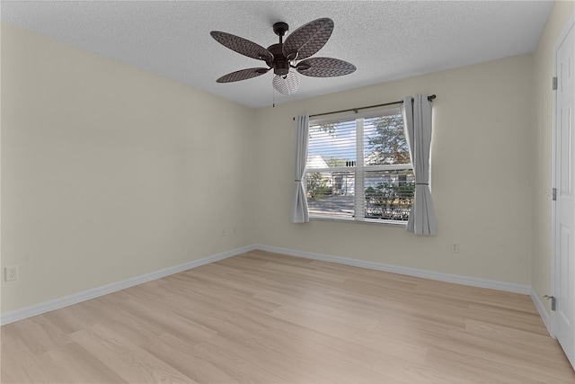 empty room with ceiling fan, light hardwood / wood-style floors, and a textured ceiling