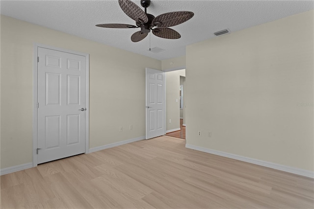 unfurnished bedroom with ceiling fan, a textured ceiling, and light wood-type flooring