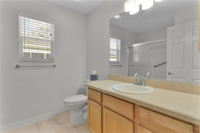 bathroom with vanity, a shower with shower door, and toilet