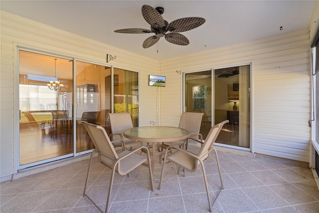 sunroom / solarium with ceiling fan with notable chandelier