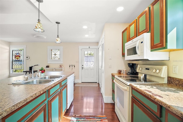 kitchen with hanging light fixtures, sink, dark wood-type flooring, and white appliances