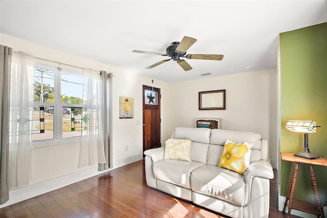 living room with dark wood-type flooring and ceiling fan