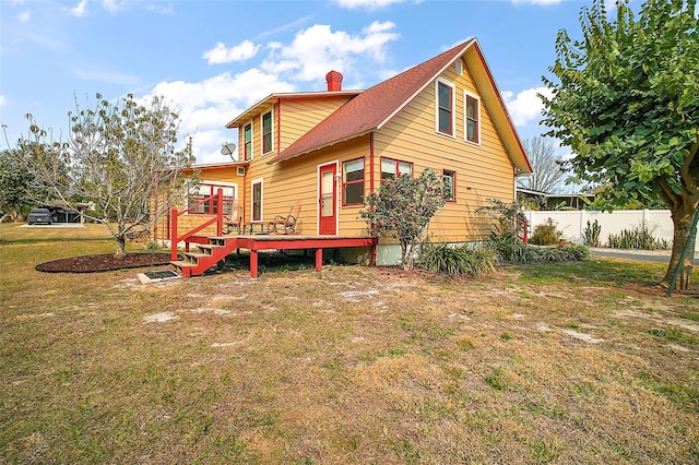 back of house featuring a lawn and a deck