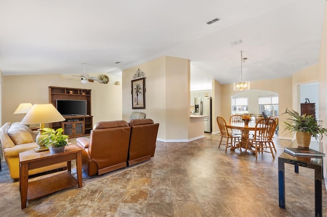 living room featuring lofted ceiling and ceiling fan with notable chandelier