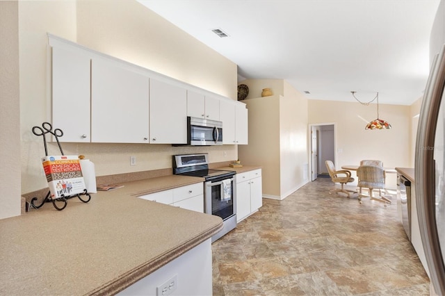 kitchen featuring appliances with stainless steel finishes, vaulted ceiling, hanging light fixtures, and white cabinets