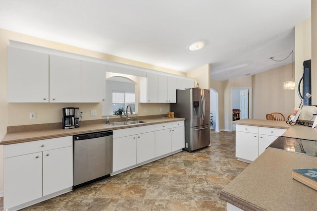 kitchen with stainless steel appliances, white cabinetry, sink, and kitchen peninsula