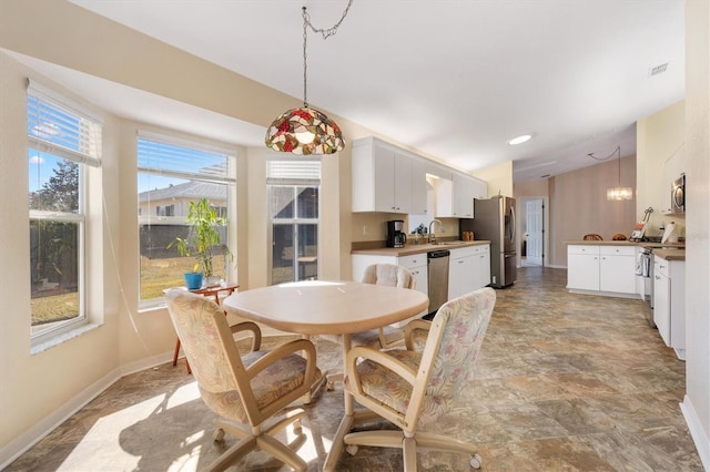 dining space with sink and vaulted ceiling