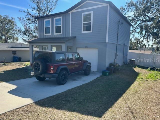 view of property featuring a garage and central AC