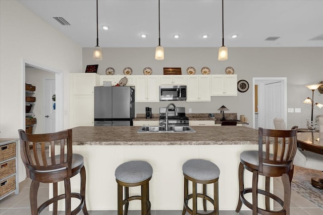 kitchen featuring white cabinetry, appliances with stainless steel finishes, sink, and decorative light fixtures