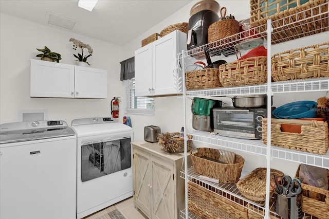 washroom featuring separate washer and dryer and cabinets