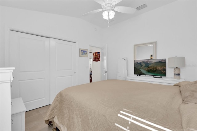 bedroom featuring light tile patterned floors, vaulted ceiling, a closet, and ceiling fan