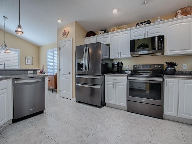 kitchen with hanging light fixtures, light tile patterned floors, white cabinets, and appliances with stainless steel finishes