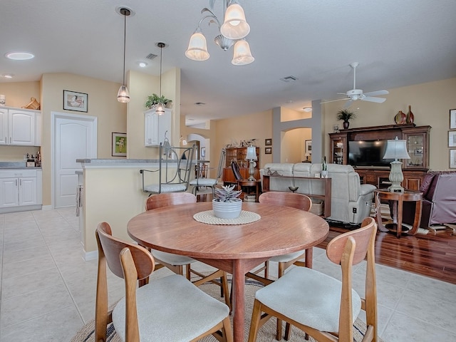 dining area with light tile patterned flooring, ceiling fan, and vaulted ceiling