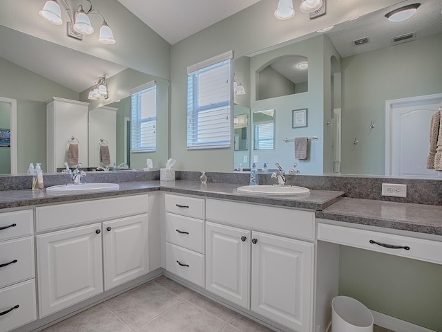 bathroom with vanity, tile patterned flooring, vaulted ceiling, and a shower with shower door