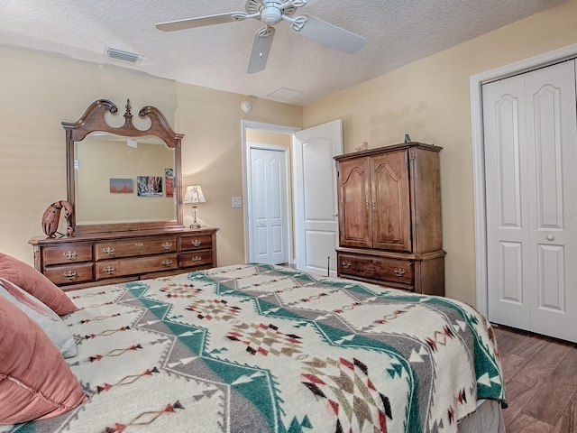 bedroom with ceiling fan, hardwood / wood-style floors, a textured ceiling, and a closet