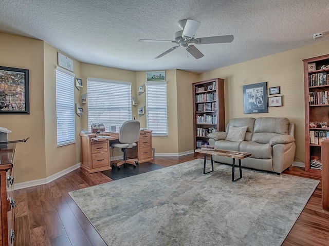 home office featuring ceiling fan, dark hardwood / wood-style floors, and a textured ceiling