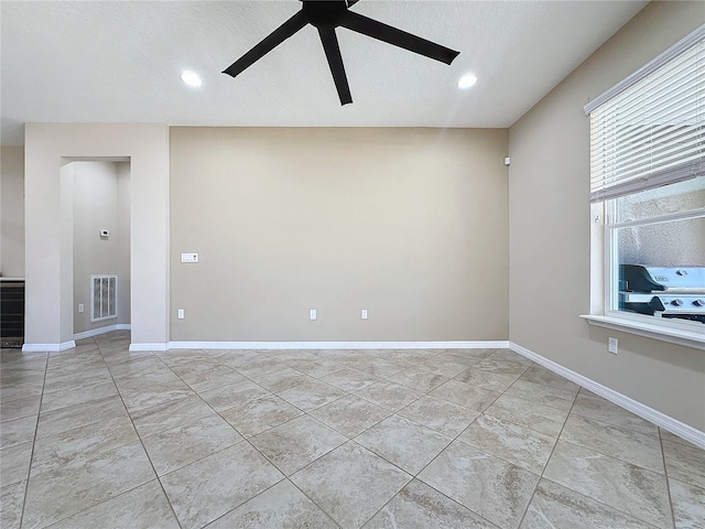 tiled spare room with ceiling fan and a textured ceiling