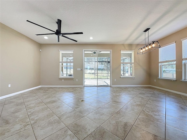 tiled spare room with a textured ceiling and ceiling fan