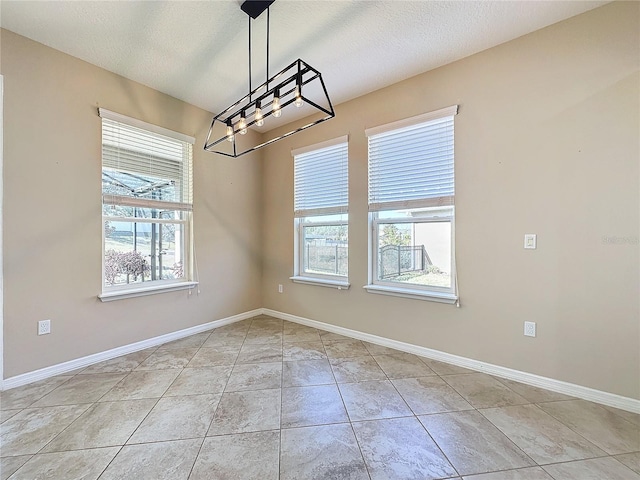 unfurnished dining area featuring light tile patterned floors and a textured ceiling