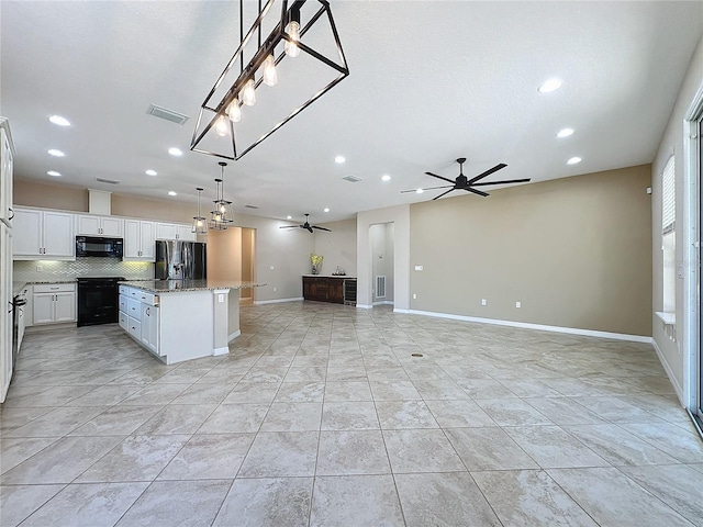 kitchen with decorative light fixtures, a kitchen island, black appliances, ceiling fan, and white cabinets