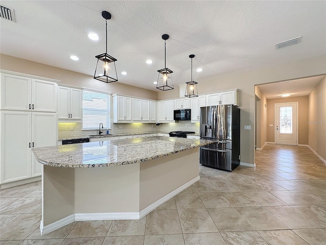 kitchen with white cabinets, a center island, and black appliances