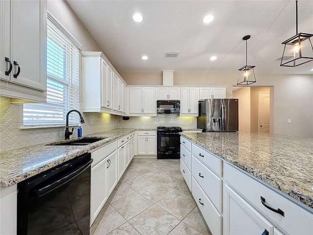 kitchen with decorative light fixtures, black appliances, sink, light stone counters, and white cabinets