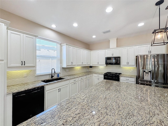 kitchen featuring white cabinetry, black appliances, light stone countertops, sink, and pendant lighting