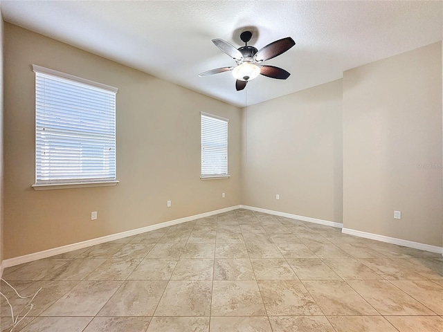 tiled spare room featuring ceiling fan and a textured ceiling