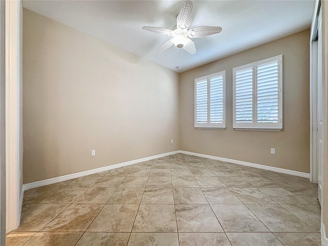 tiled spare room with ceiling fan and a textured ceiling