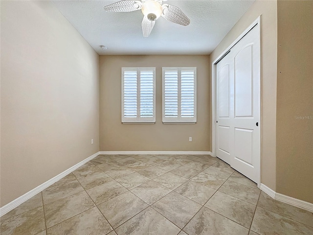 unfurnished bedroom with light tile patterned floors, ceiling fan, a closet, and a textured ceiling