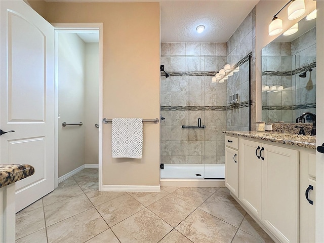 bathroom with a textured ceiling, tile patterned flooring, vanity, and a shower with door